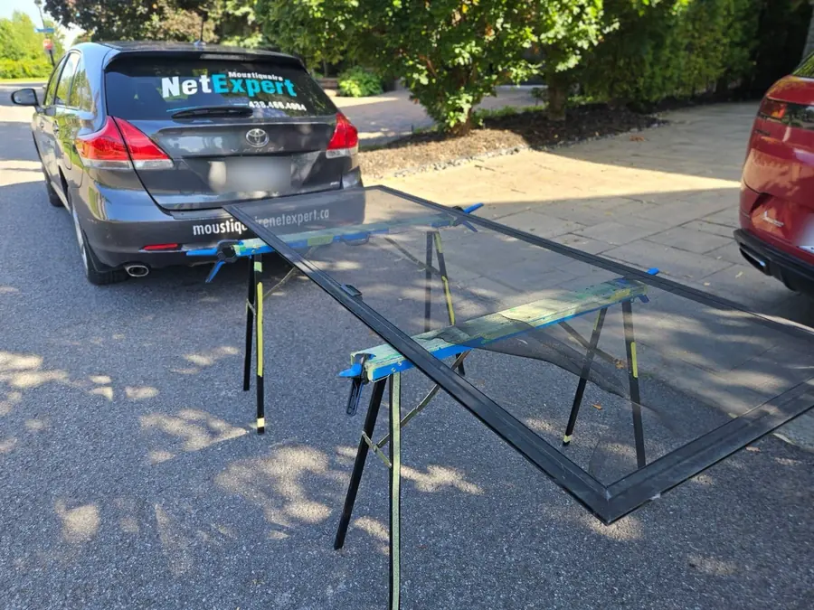 Porte-patio démontée sur nos tréteaux, devant le véhicule de l’entreprise